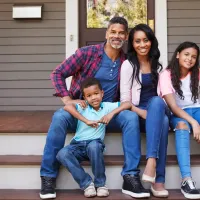 family sitting on front porch of pest free home