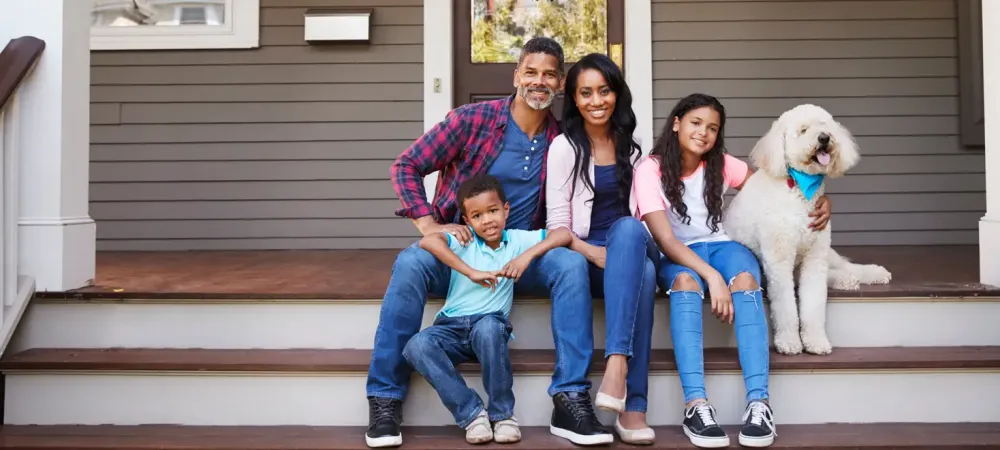 family sitting on front porch of pest free home